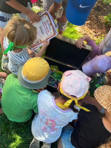Kinder mit Stirnbändern öffnen gemeinsam die Schatztruhe